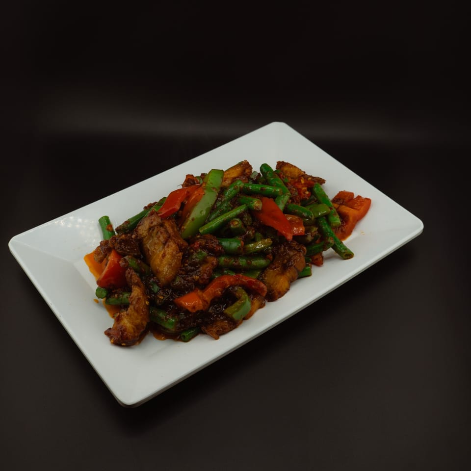 Tuk Tuk Thai Campbell's spicy stir-fried green beans, bell peppers, and chicken on a white rectangular plate.