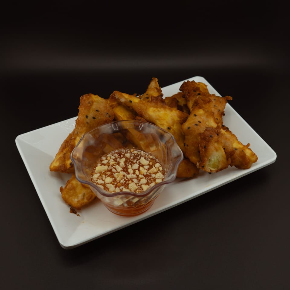 Golden fried bananas with black sesame seeds, served with a sweet peanut dipping sauce.